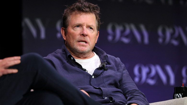 Michael J. Fox sitting in front of dark blue backdrop