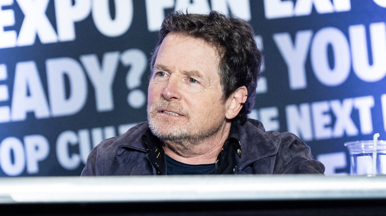 Michael J. Fox listening onstage during an event