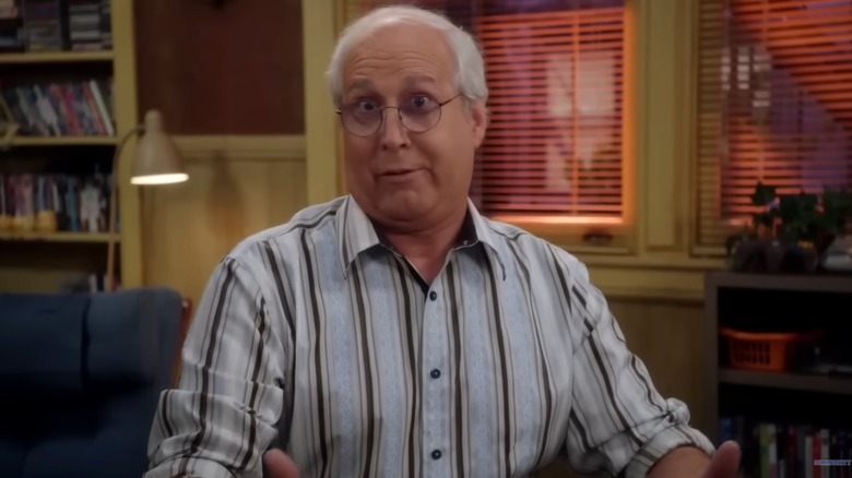 Chevy Chase wearing glasses and striped shirt on set of Community