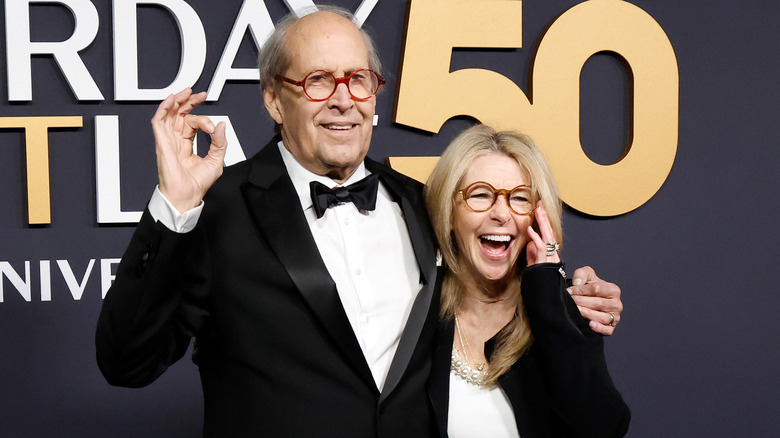 Chevy and Jayni Chase smiling on SNL50 step-and-repeat