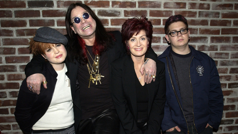 Kelly Osbourne in gray cap and black jacket with father Ozzy, mom Sharon, and brother Jack