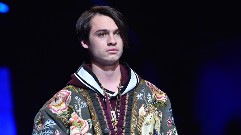 Dylan Jagger Lee walking the runway in a bedazzled green jacket