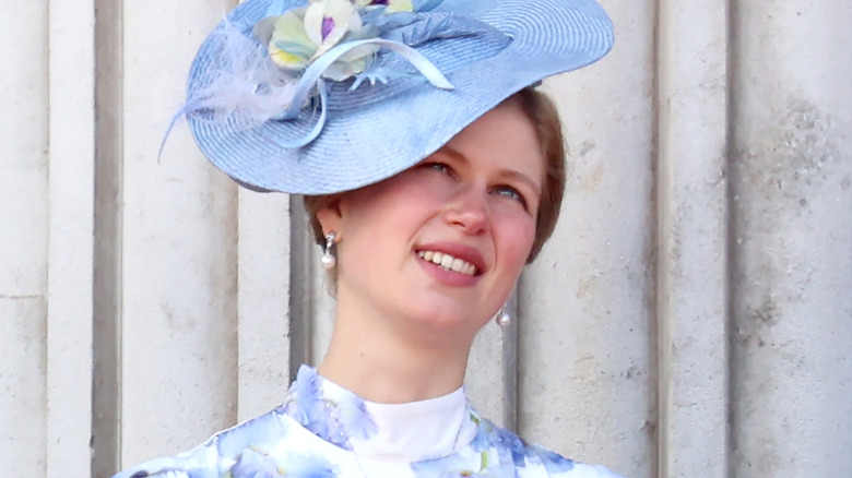 Lady Louise Mountbatten-Windsor smiling and looking up in a blue hat