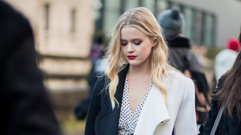 Ava Phillippe outside, looking down, in a black and white outfit.
