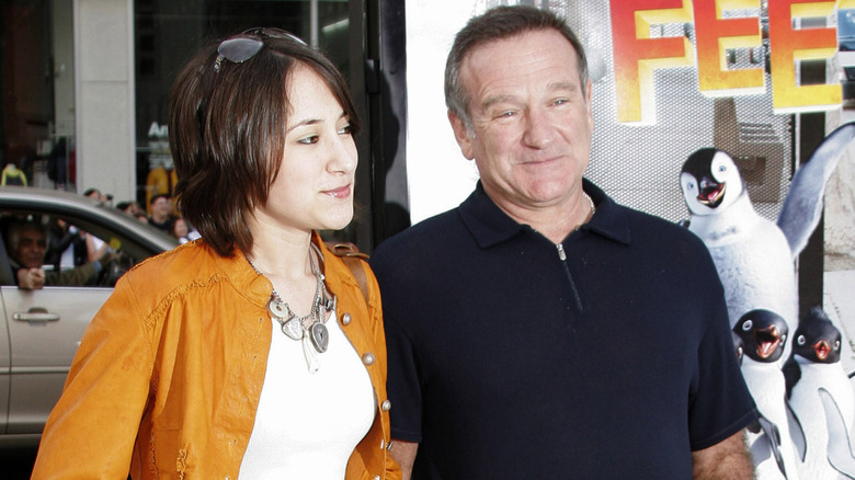 Zelda Williams and Robin Williams standing near 'Happy Feet' poster
