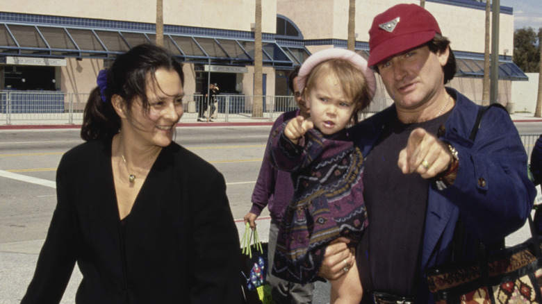 Marsha Garces Williams walking with Robin Williams, who is carrying a young Zelda williams