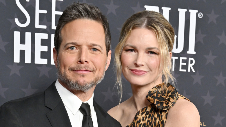 Scott Wolf in a black tie and Kelley Wolf in an animal print dress