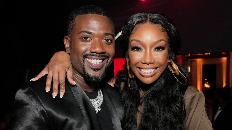 Brandy Norwood smiling while posing with her arm around Ray J
