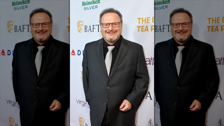 A slim Wayne Knight posing on a step-and-repeat