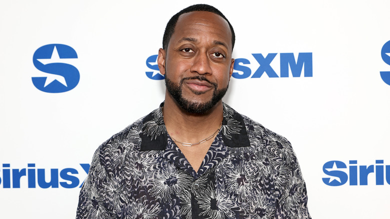 Jaleel White posing on the red carpet in a white and black shirt