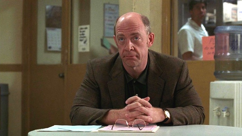 J.K. Simmons as Dr. Emil Skoda, sitting with his hands folded on the table in front of him, in "Law & Order"