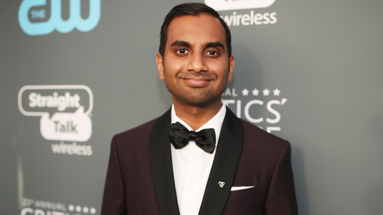 Aziz Ansari smiling at the Critics Choice Awards wearing suit