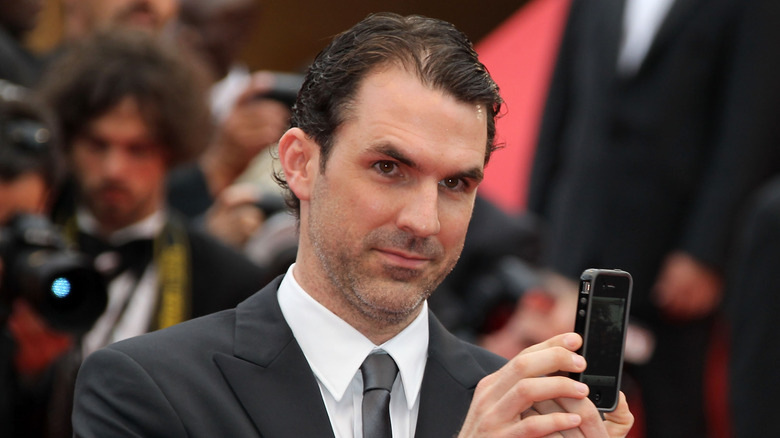 Paul Schneider taking a picture with his phone on the red carpet