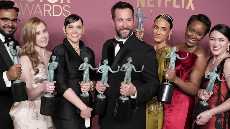 Cast of The Pitt posing on step-and-repeat holding their SAG awards
