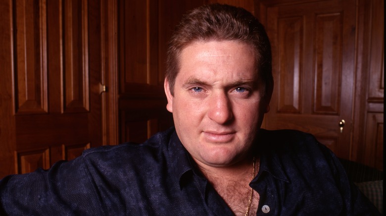 Chris Penn posing for photos in an open navy shirt