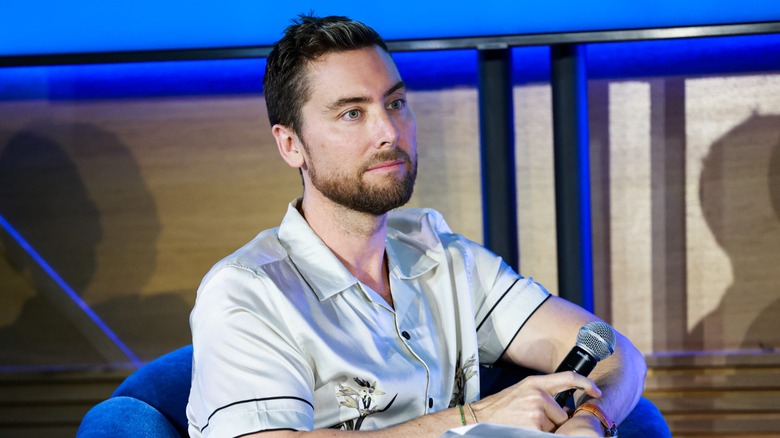Lance Bass speaking at a summit in 2022