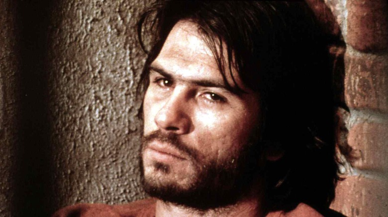 Tommy Lee Jones as a young man with a beard and shaggy hair