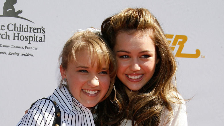 Young Emily Osment and Miley Cyrus hugging