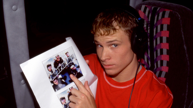 Brian Littrell pointing to a photo of Backstreet Boys