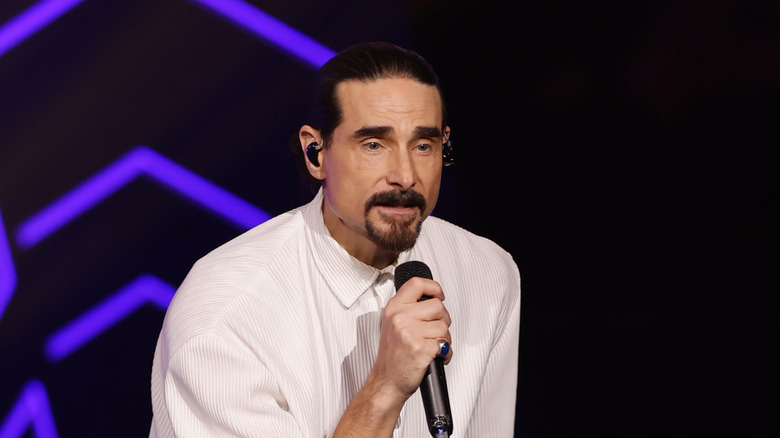 Kevin Richardson singing in a white button-up shirt