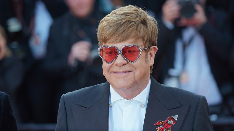 Elton John attends a movie premiere wearing heart-shaped glasses