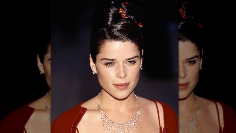 Neve Campbell with an updo wearing red
