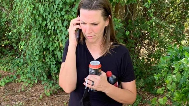 Amanda Brumfiled speaking on the phone near leafy plants