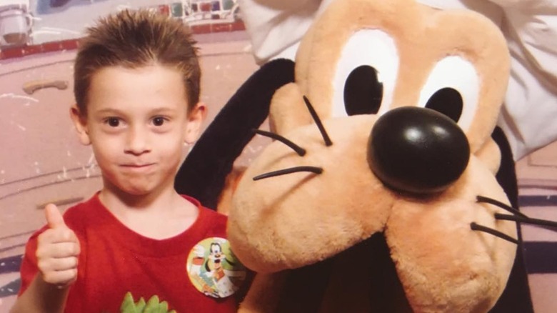 Tyler Henry giving thumbs up next to Goofy mascot
