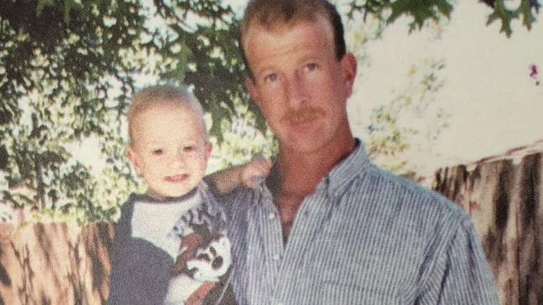 Tyler Henry smiling in his dad's arms as an infant