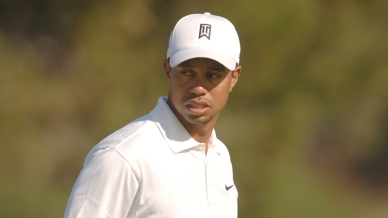 Tiger Woods walking on the golf course with his hat on