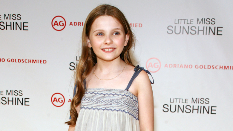 Young Abigail Breslin smiling on step-and-repeat