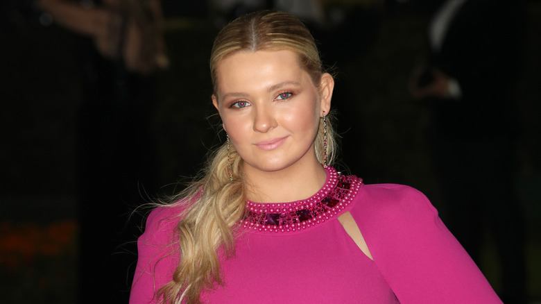 Closeup of Abigail Breslin posing in a bright pink dress