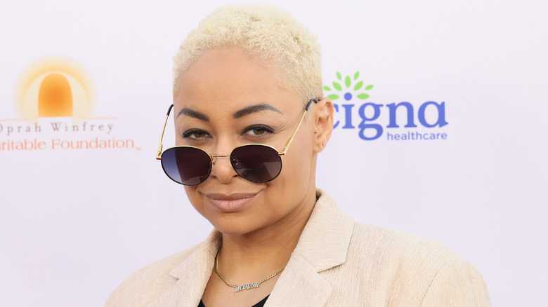 Raven-Symoné wearing sunglassees and cropped hair at a gala