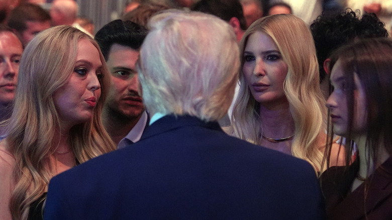 Tiffany and Ivanka Trump looking at Donald Trump who's back is facing the camera