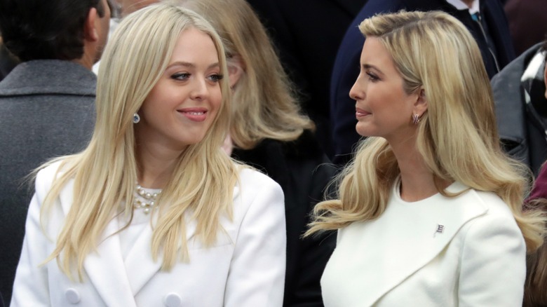 A smiling Tiffany Trump looking at a serious-looking Ivanka Trump