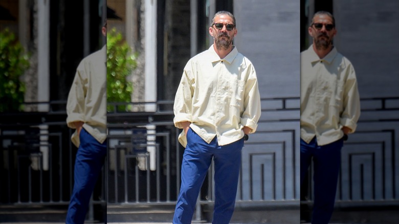 A photo of Shia LaBeouf in sunglasses and oversized button down shirt taking a walk in the streets