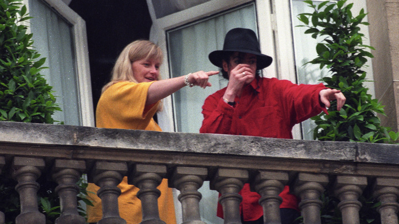 Michael Jackson and Debbie Rowe pointing at something while on a balcony in 1997