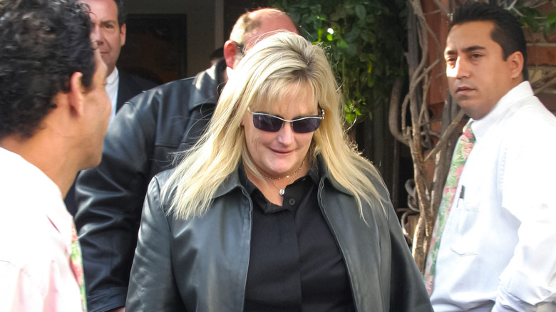 Debbie Rowe (wearing black with sunglasses) walking down the street in 2004