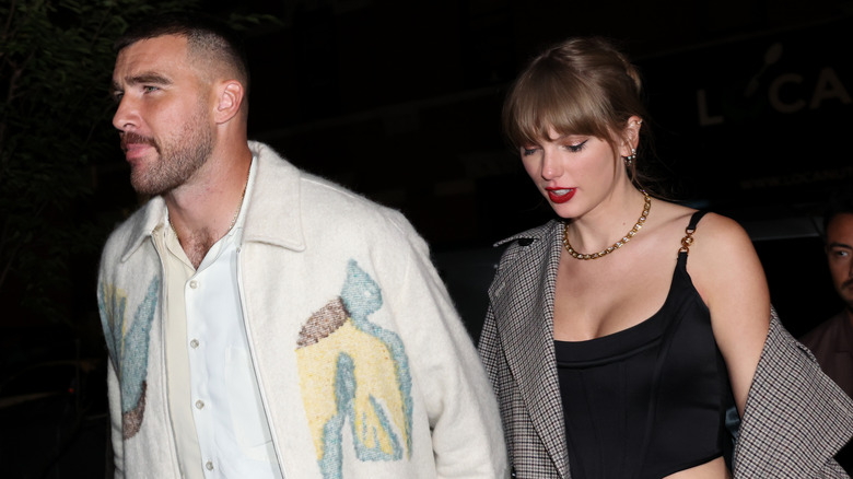 Travis Kelce and Taylor Swift walking into a restaurant