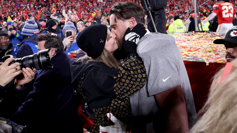 Taylor Swift and Travis Kelce kissing in a crowd
