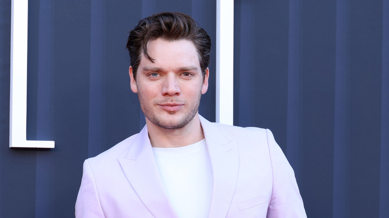 Dominic Sherwood in a pale lavender suit and white t-shirt