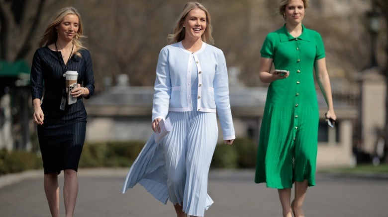 Karoline Leavitt dressed in blue walks to a group of reporters outside the West Wing of the White House (2025)