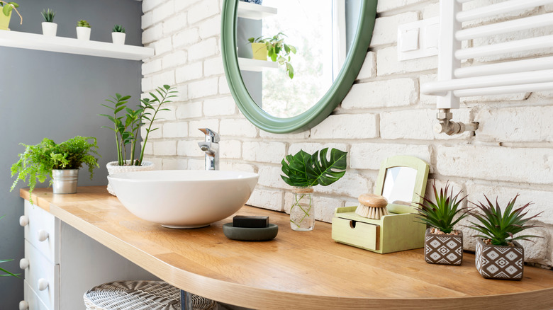 white modern bathroom with raised sink and wood countertop