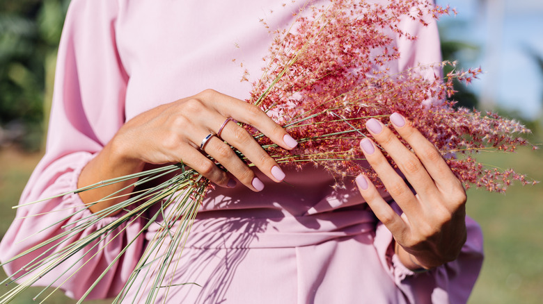 hands holding pink bouquet