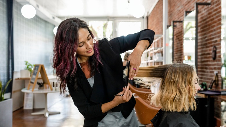 Hairstylist trimming hair