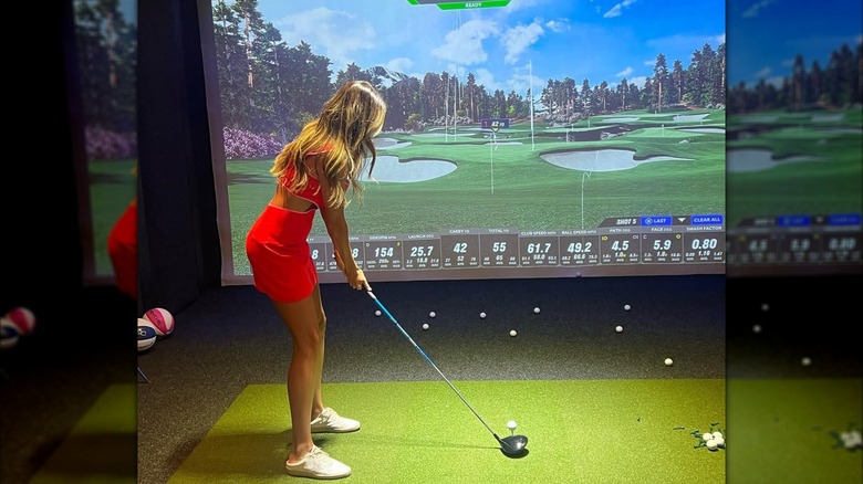 Margo Martin plays a round of golf on a golf simulator in September 2023 (2023)