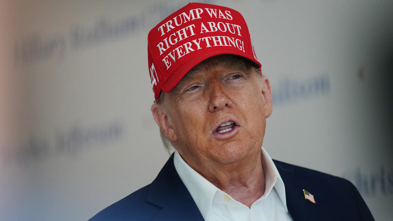 Donald Trump talking and wearing a red "Trump Was Right About Everything!" hat
