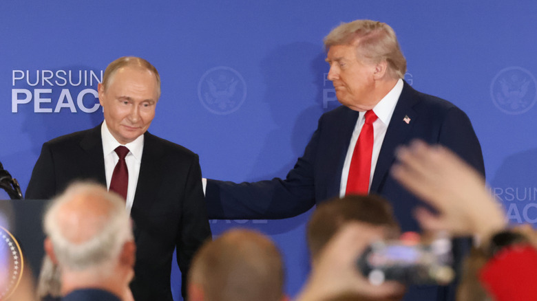 Donald Trump patting Vladimir Putin's back while both are wearing suits