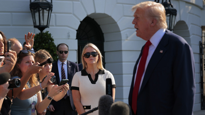 Donald Trump speaking to crowd next to Karoline Leavitt