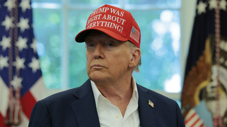 Donald Trump wearing a Trump Was Right About Everything hat in the Oval Office